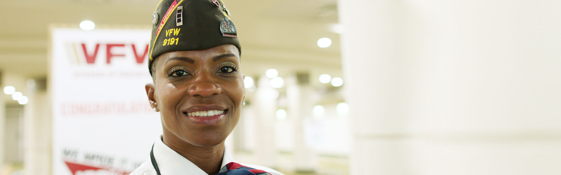 A woman member of the Veterans of Foreign Wars smiling while wearing her brown VFW cover