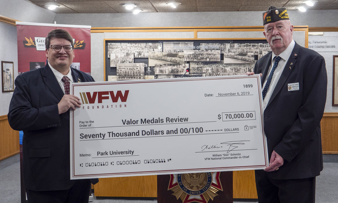 Park University President Dr. Greg Gunderson left accepts a donation from VFW National Commander William Doc Schmitz