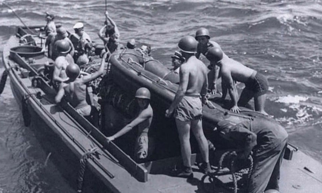 a landing craft personnel ramped carries frogmen and a seven-man IBS to their drop-off point during world War II