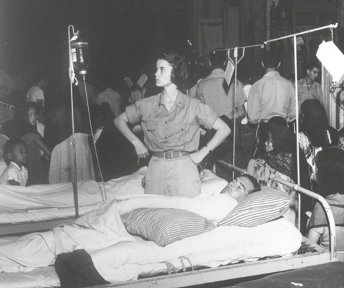 Female nurse looks at patient's IV