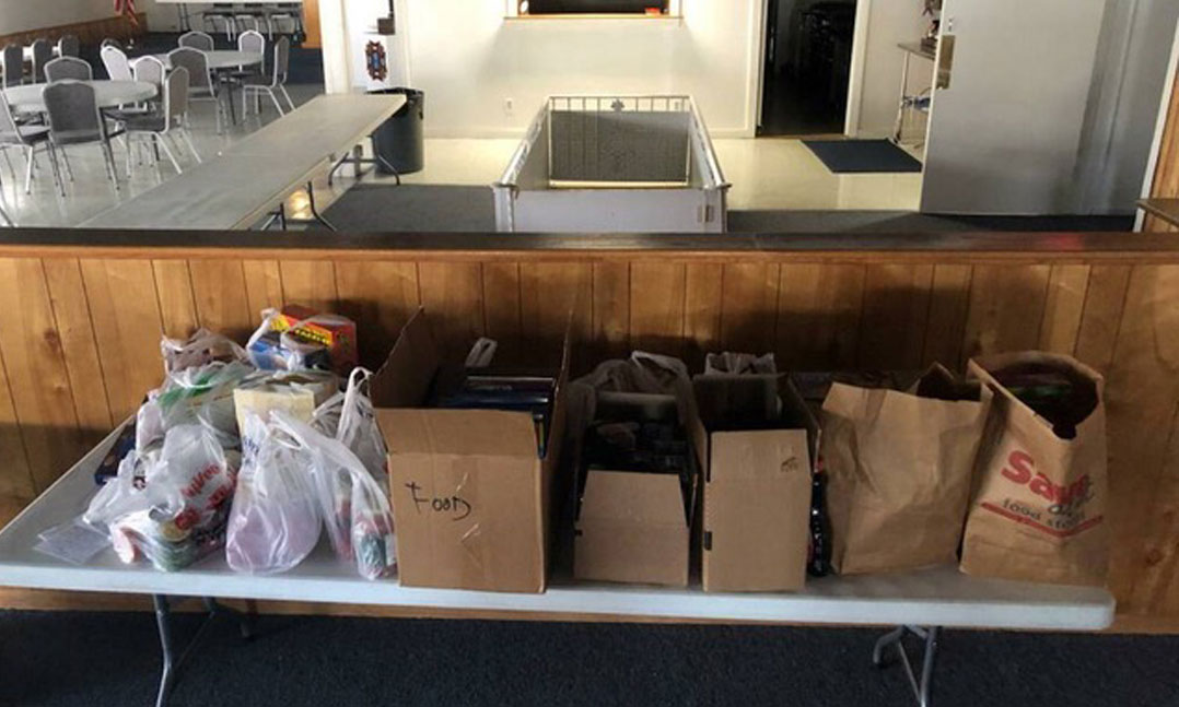 Donated food supplies during COVID-19 are stacked on a VFW Post table