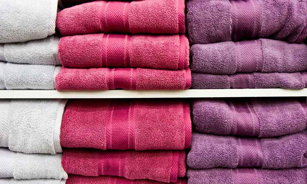 Stacks of white, pink and purple bath towels