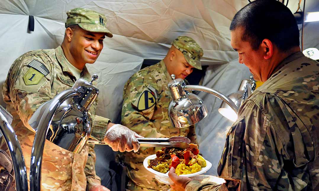 Service members serving Thanksgiving dinner during deployment
