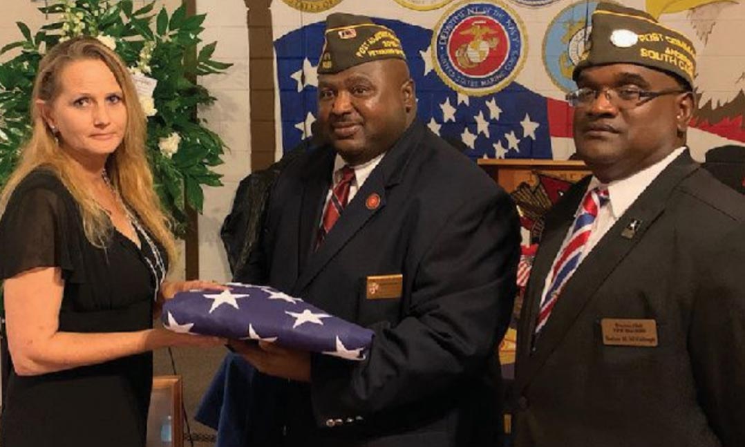 James Beaty, center, and current VFW Post 6089 Commander Rodney McCullough, right, present a folded flag to a family member of a Vietnam veteran who had recently passed away in Anderson County, S.C.