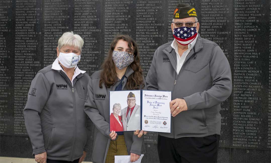 VFW National Commander Hal Roesch II (right) and VFW Auxiliary President Sandi Onstwedder (left) present Voice of Democracy first place winner Erin Stoeckig (center) with her $30,000 award
