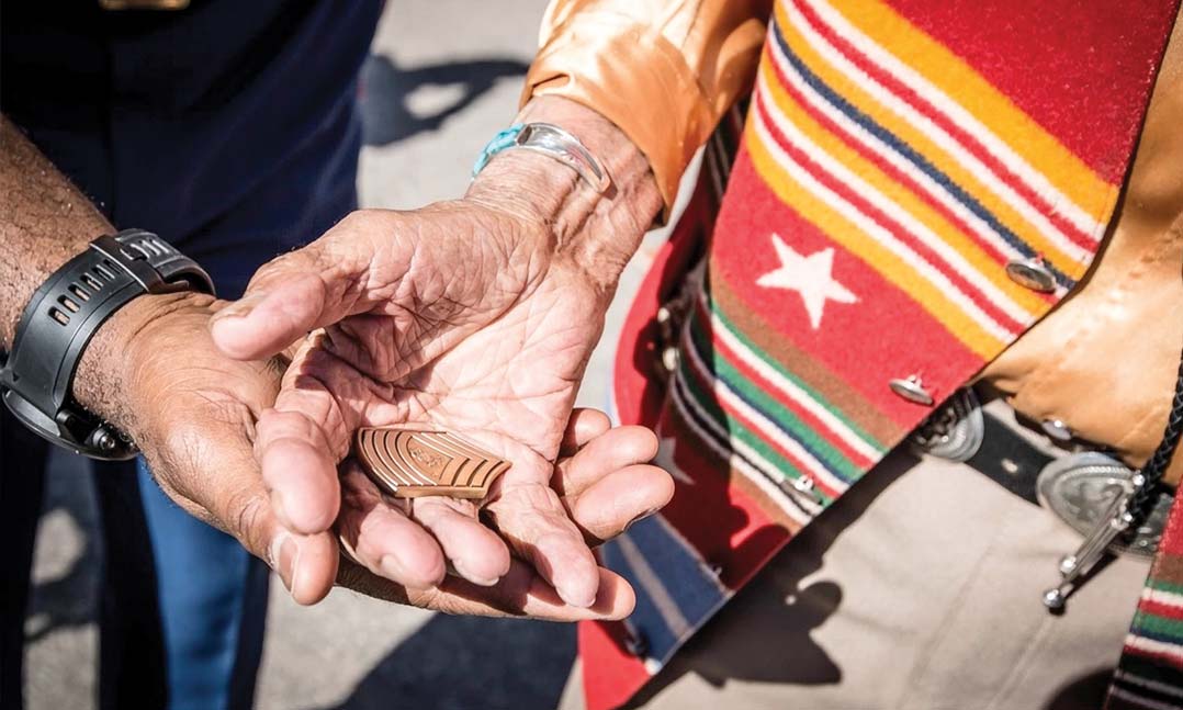 Тогдашний сержант морской пехоты Рональд Грин вручает свою монету вызова носителю кода навахо 14 августа 2016 г.
