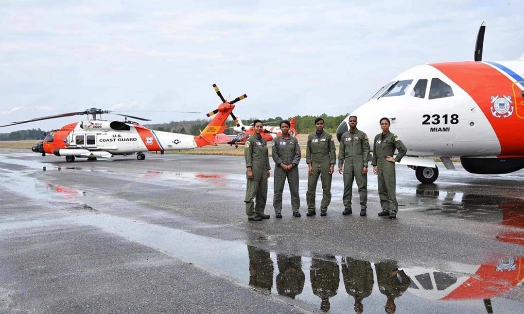 (From left to right) Coast Guard pilots Lt. Cmdr. Jeanine Menze, Cmdr. LaShanda Holmes, Lt. Angel Hughes, Lt. Chanel Lee and Lt. Ronaqua Russell stand in front of Coast Guard aircraft in February 2019 at the Tuskegee Airmen National Historic Site in Alabama.