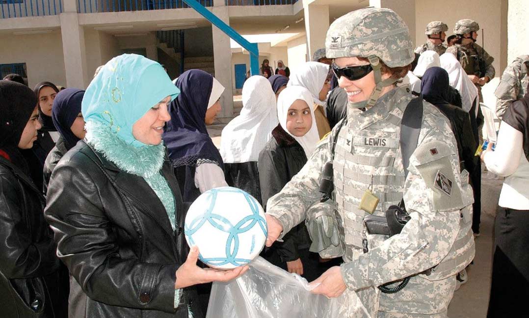 Then-Col. Debra Lewis presents soccer balls in February 2007 to the head mistress of an all-girls school in Baghdad, Iraq.