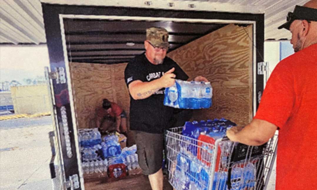 Two members of VFW Post 3665 collect water for those in need after Hurricane Ida