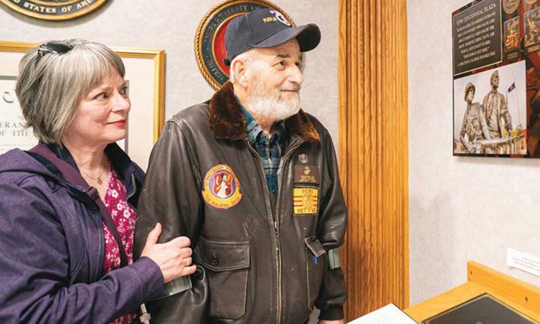 John Musgrave and his wife, Shannon, read the plaque devoted to the history of VFW’s “Citizen-Soldier,” of which John was chosen as the model in 1998.