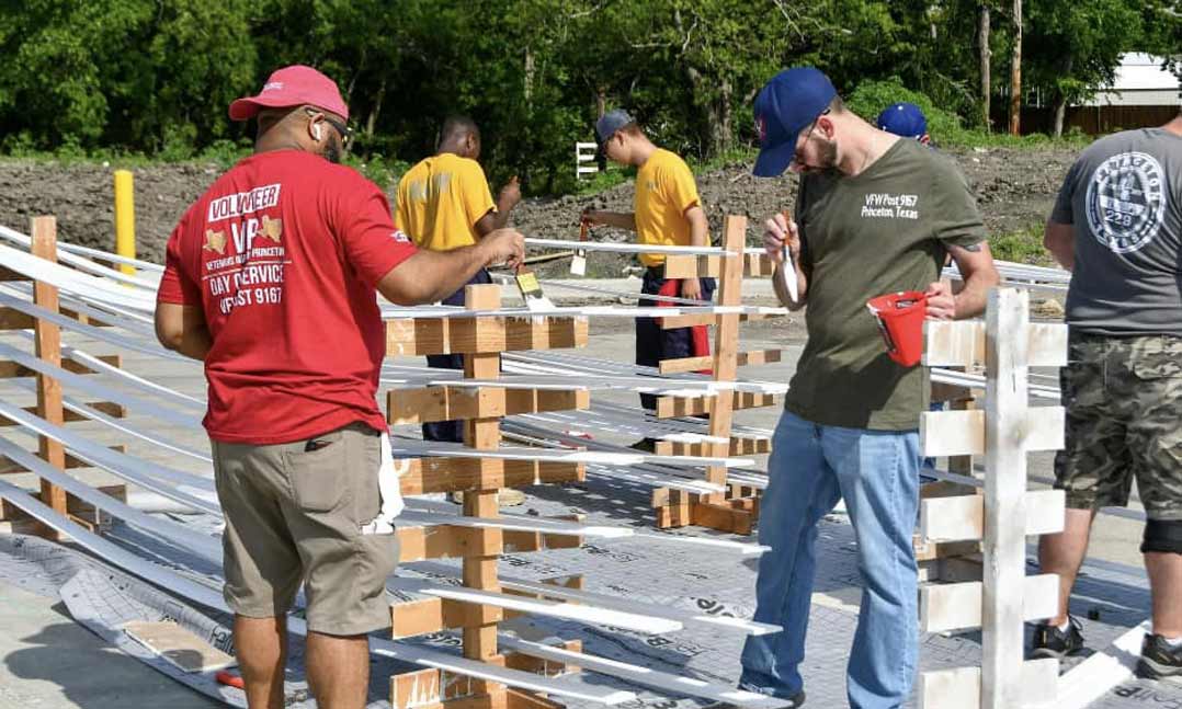 VFW Post 9167 members from Princeton, Texas, work with local JROTC cadets and volunteers of Habitat for Humanity to paint and help build homes for those in need