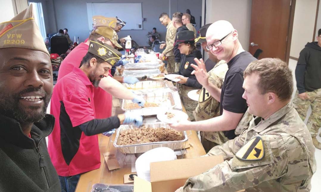 VFW Post 12209 Commander Willie Keller, left, takes a photo while he and his Post members serve lunch to members of the 115th Brigade Support Battalion, 1st Armored BCT, 1st Cavalry Division