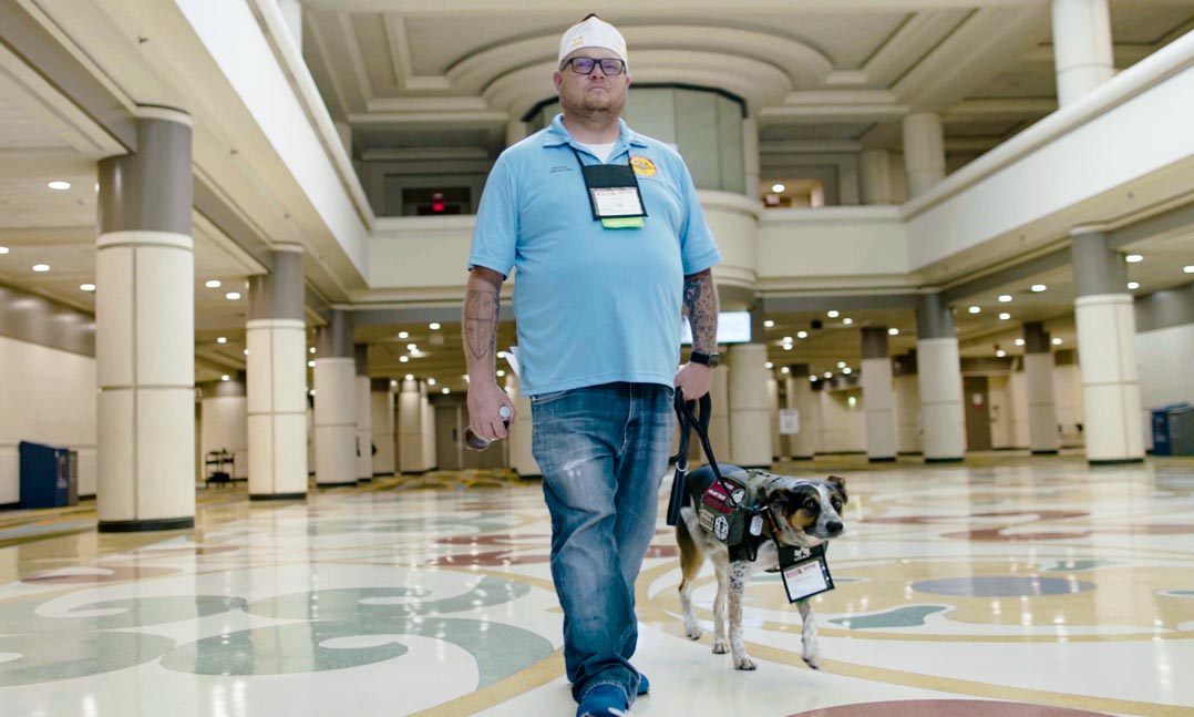 Male veteran with a service dog wearing glasses