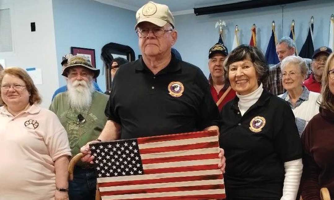 Marine and Vietnam War veteran Tom Ashmore receives a U.S. flag after he concludes a Cane-Fu lesson on behalf of his Cane Loyalty program with members of VFW Post 4639