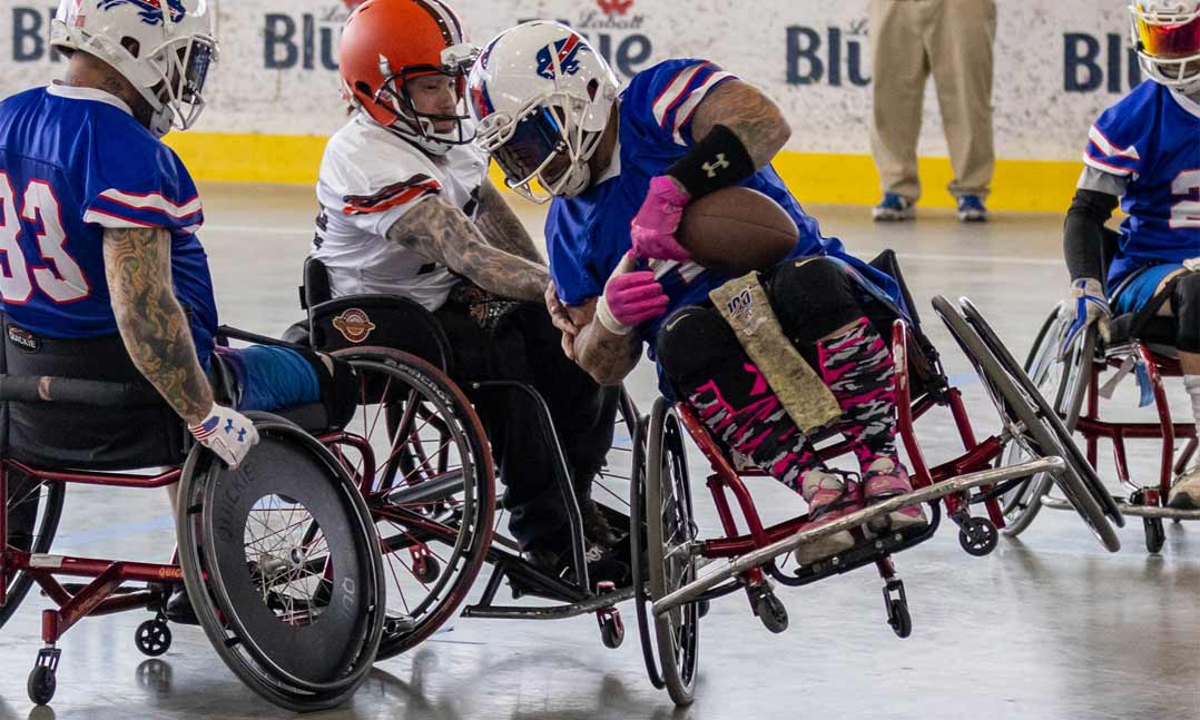 Army veteran Matt Daniels of the Buffalo Bills wheelchair football team (left, with ball), eludes a defender from the Cleveland Browns