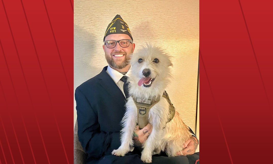 A veteran smiling with his service dog