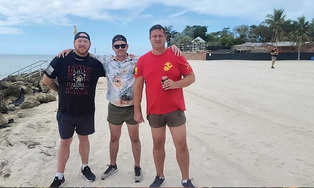 three men standing on a beach after a silkies hike