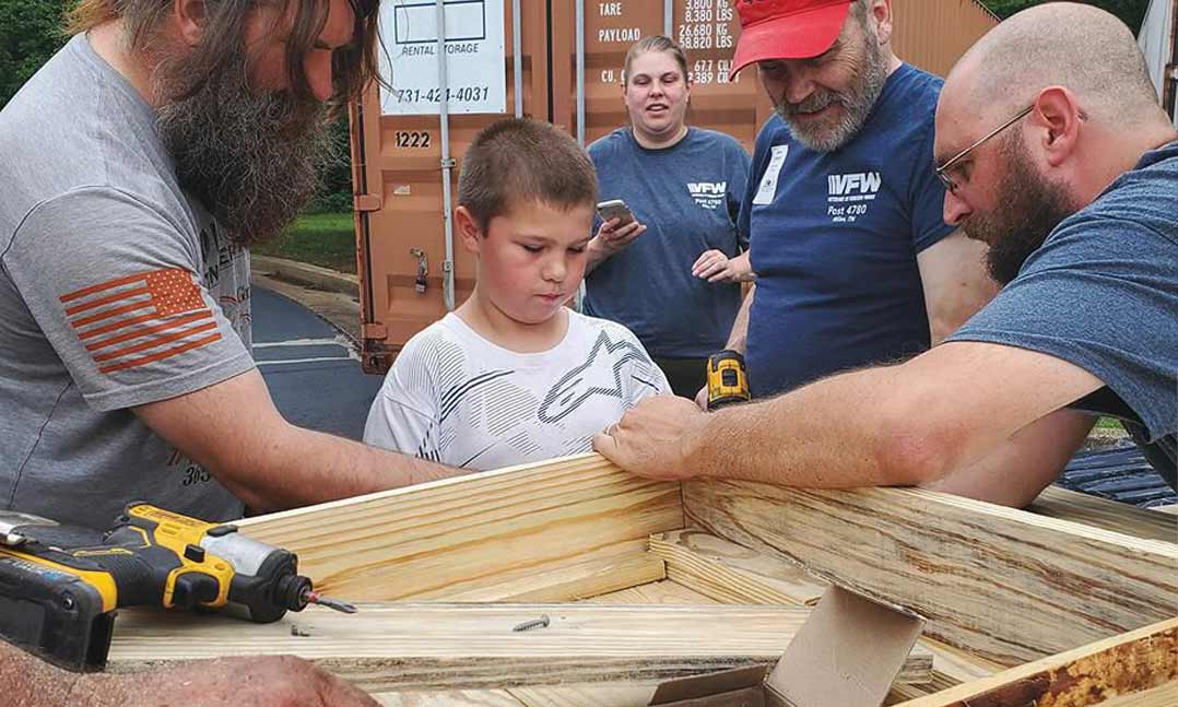 veteran volunteers build flower boxes for a veterans care facility