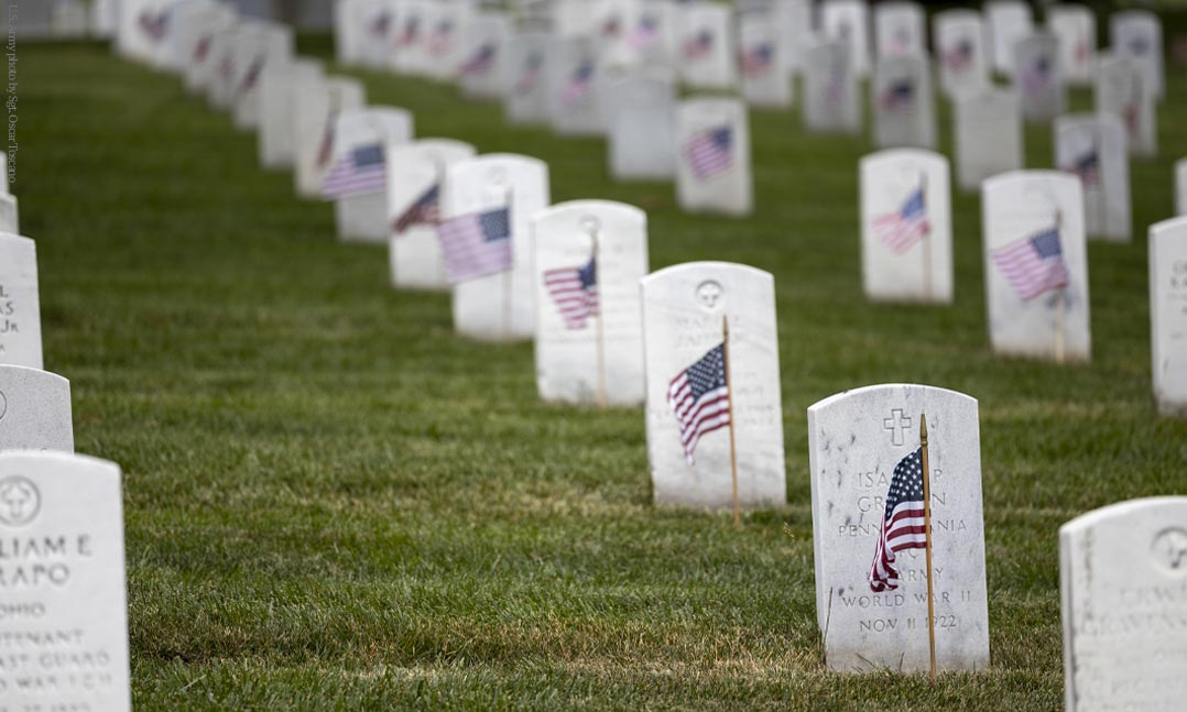 Graves at Arlington National Cemetery with a US flag placed in front
